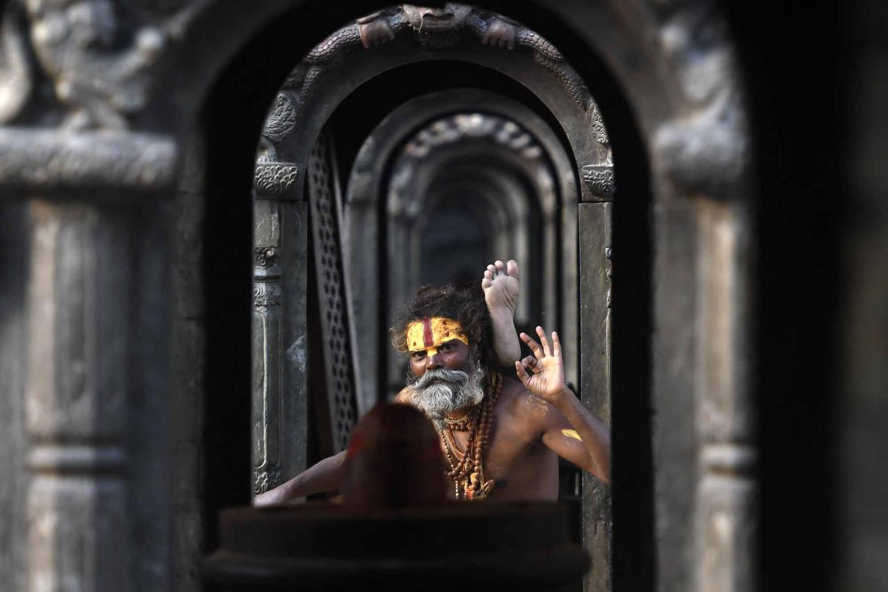 A Sadhu or Hindu holy man poses for picture at the Pashupatinath temple area in Kathmandu on April 27, 2022. (Photo by PRAKASH MATHEMA / AFP)
