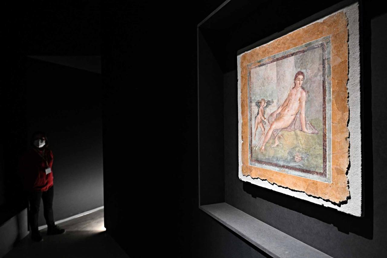 This photograph shows a part of a new exhibition in Pompeii's site entitled "Art and sensuality in the houses of Pompeii" on art and sexuality in the ancient city, where sculptures and paintings of breasts and buttocks abounded, on April 28, 2022. - Raunchy scenes may redden faces at a new exhibition in Pompeii on art and sexuality in the ancient Roman city, where sculptures and paintings of breasts and buttocks abounded. Archaeologists excavating the city, which was destroyed by the eruption of nearby Vesuvius in 79 AD, were initially startled to discover erotic images everywhere, from garden statues to ceiling frescos. (Photo by Andreas SOLARO / AFP)