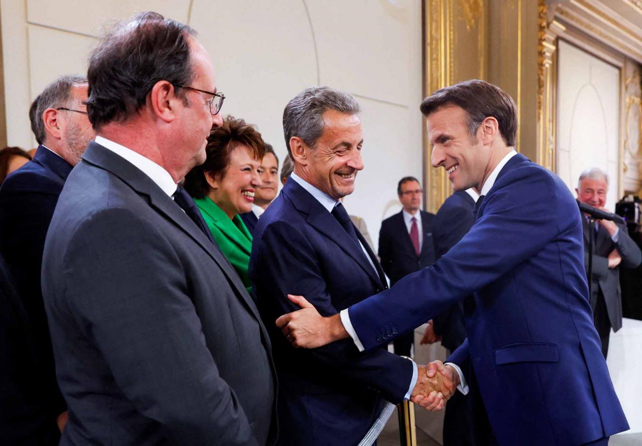 France's former President Francois Hollande (L) looks on as France's former President Nicolas Sarkozy shakes hands with French President Emmanuel Macron (R) after he is sworn-in for a second term as president following his re-election on April 14, during a ceremony at the Elysee Palace in Paris, on May 7, 2022. (Photo by GONZALO FUENTES / POOL / AFP)