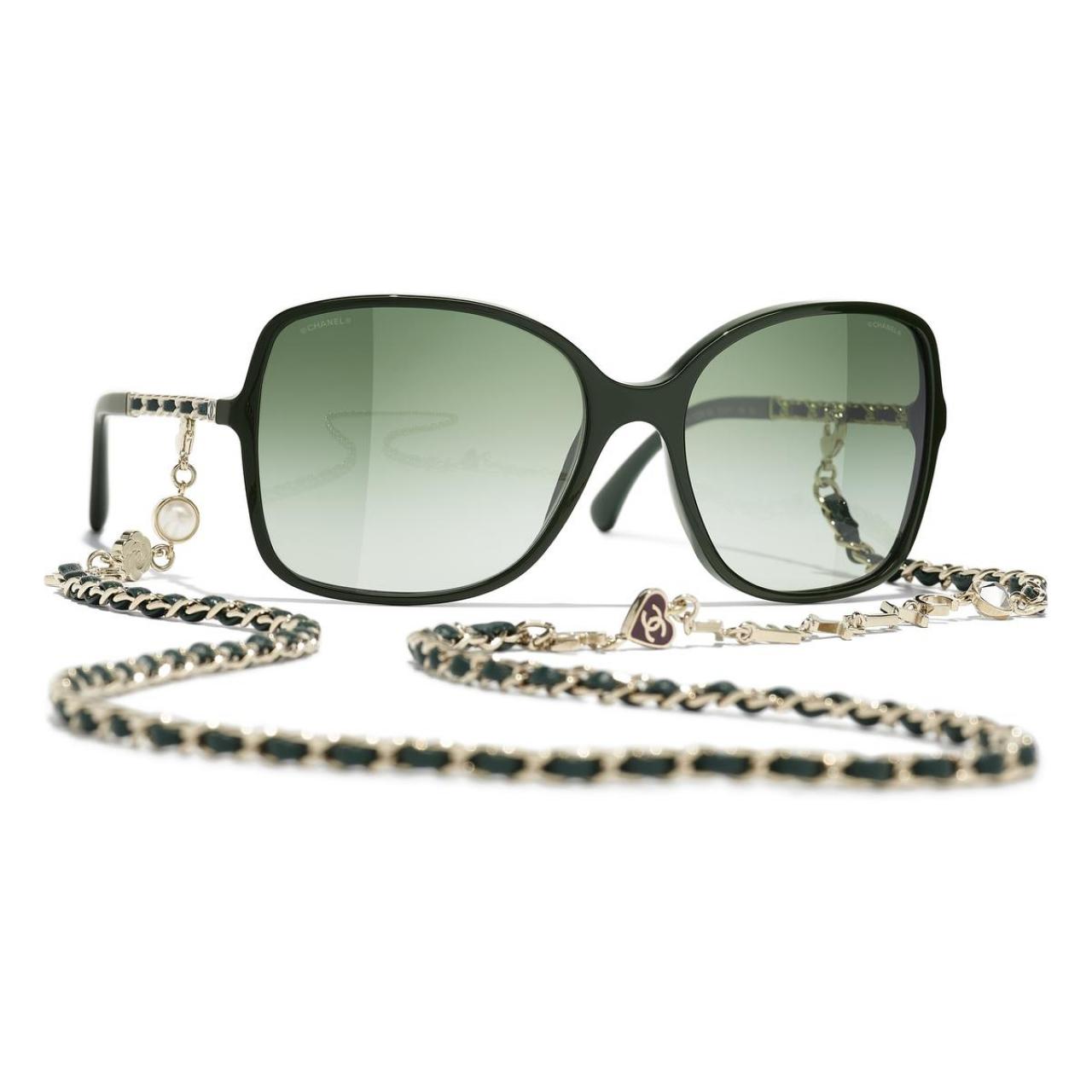 Aan de kettingZo raak je je zonnebril nooit meer kwijt: model van Chanel met een afneembare ketting in leder en metaal, versierd met hartjes, een camelia en parels (1.150 euro).