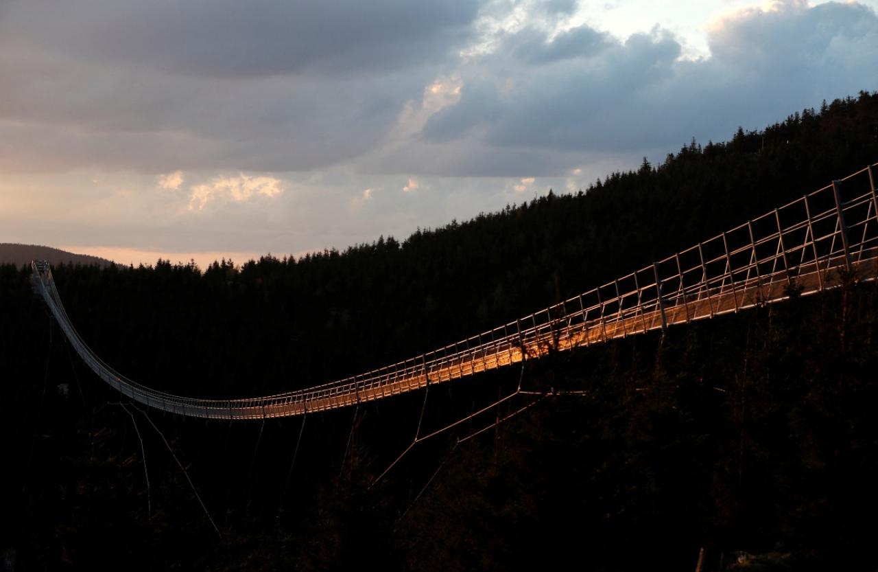 A staff member walks across the newly-built world's longest suspension bridge a day before its official opening in the mountain resort of Dolni Morava, Czech Republic, May 12, 2022. Picture taken May 12, 2022. REUTERS/David W Cerny *** Local Caption *** CAPTION TEST 01