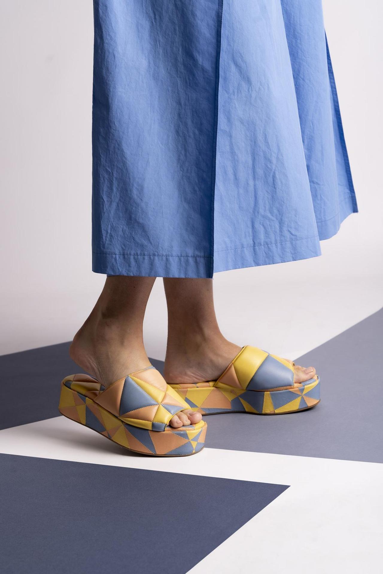 KleurenvakjesKleurrijke slippers met plateauzool en geometrisch motief (325 euro), van de Belgische designer Sam Reychler.