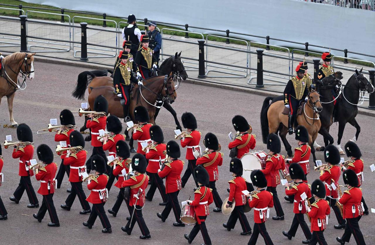 The Band of the Welsh Guards pass mambers of the Kings Troop Royal Horse Artillery on their way to the Queen's Birthday Parade, the Trooping the Colour, as part of Queen Elizabeth II's platinum jubilee celebrations, on June 2, 2022, in London. - Huge crowds converged on central London in bright sunshine on Thursday for the start of four days of public events to mark Queen Elizabeth II's historic Platinum Jubilee, in what could be the last major public event of her long reign. (Photo by Paul ELLIS / POOL / AFP)