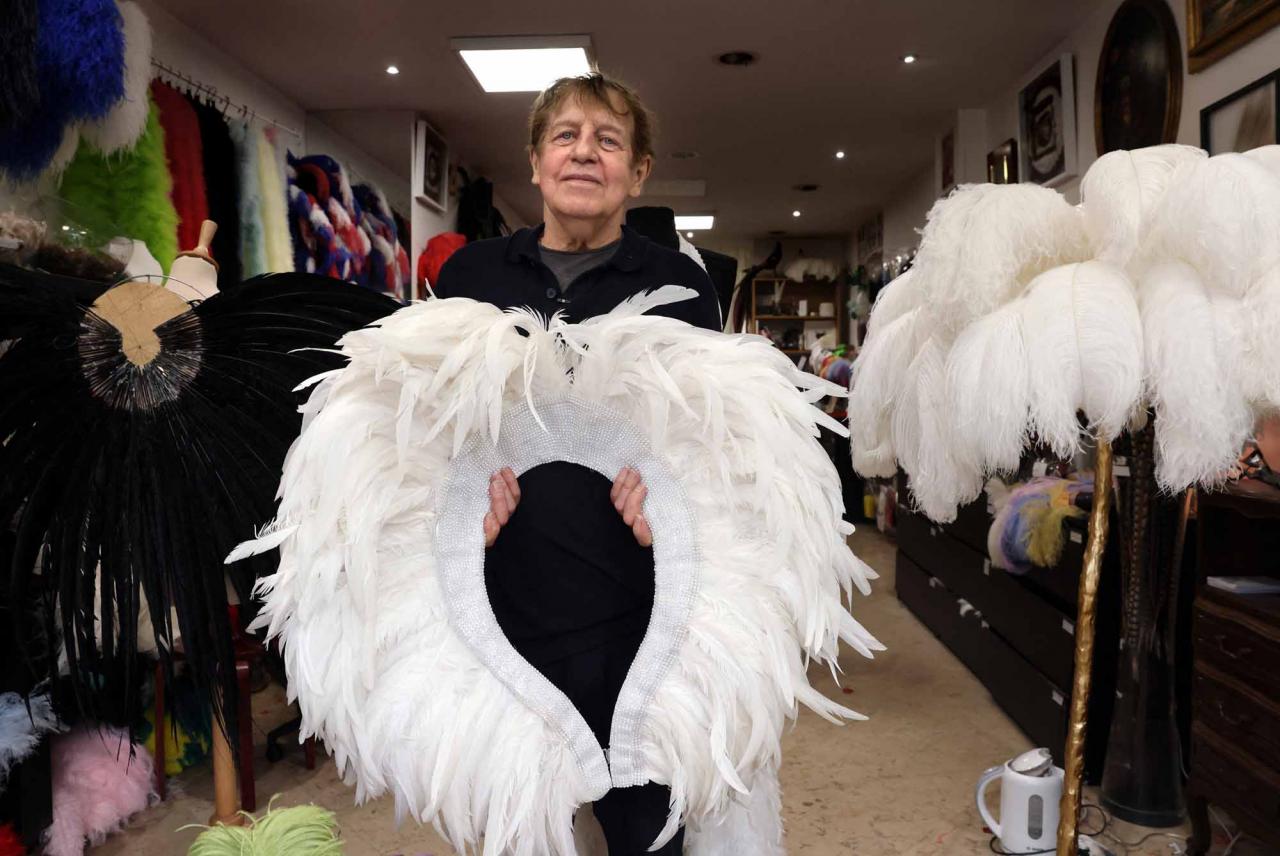 Dominique De Roo, official feather craftsman of the Lido poses inside his workshop in Paris on June 1, 2022. - The Lido cabaret, an institution for Parisian night life since 1889, is set to lay off 157 of 184 employees, including its "Bluebell girls" troupe of dancers, announced the new owner, French hotels giant Accor. (Photo by Thomas COEX / AFP)