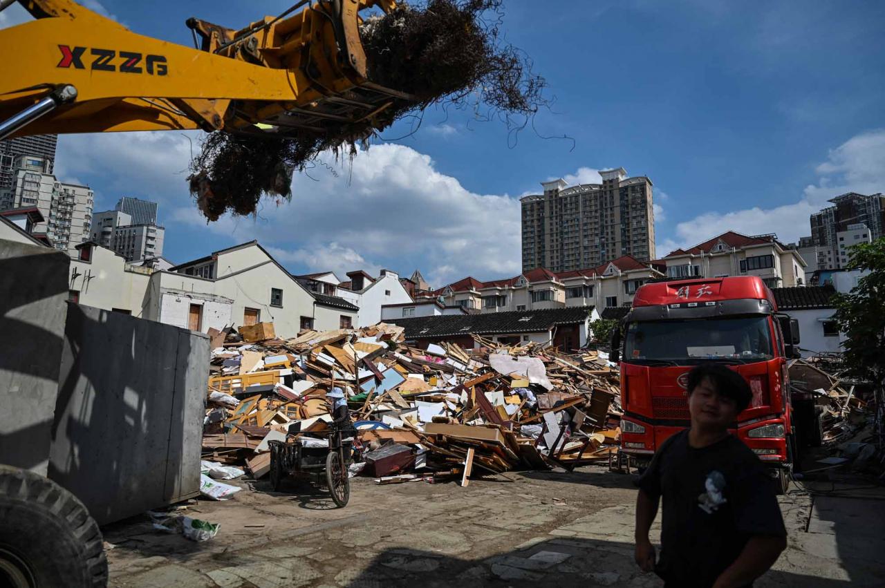 This photo taken on July 6, 2022 shows timber and debris from demolished houses in the Laoximen neighbourhood of Shanghai's Huangpu district. - Bricked-up doorways, crumbling facades, and a small group of defiant locals: one of Shanghai's oldest neighbourhoods is barely clinging to life as the city presses ahead with demolition and redevelopment plans. (Photo by Hector RETAMAL / AFP)