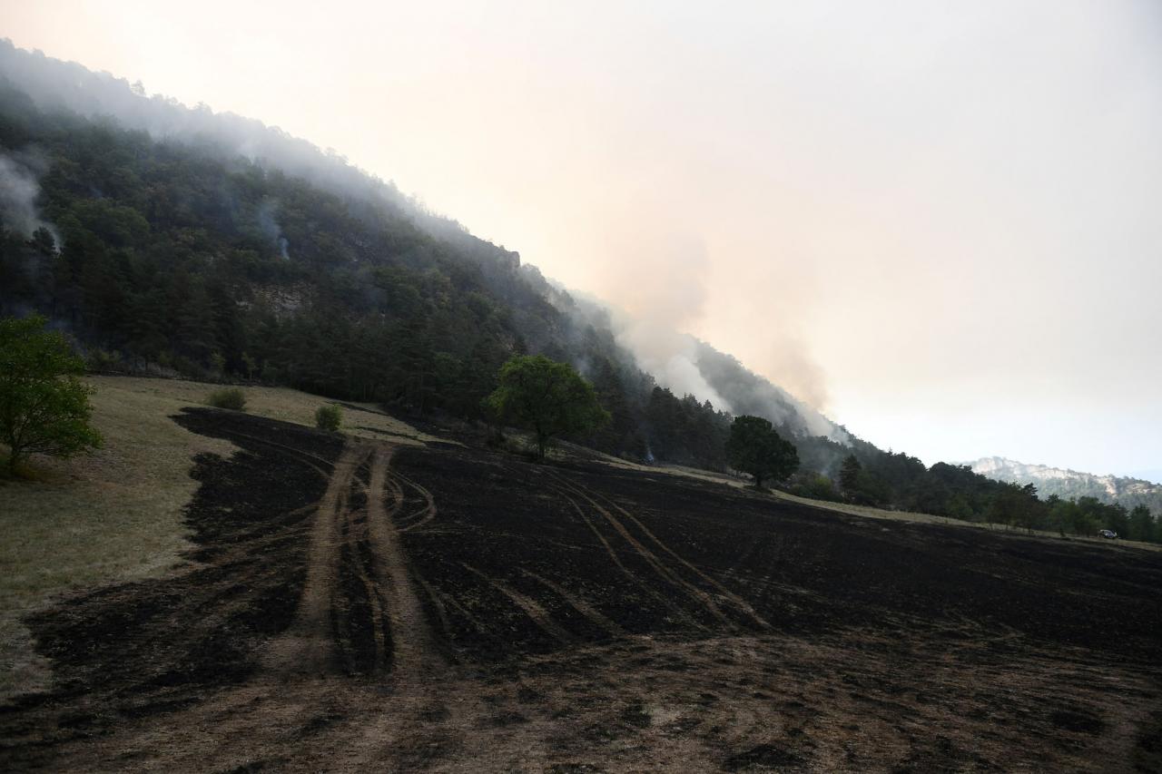 The photograph taken in Mostuejouls, southern France, on August 9, 2022, shows an area burnt by the firefighters to slow the advance of a fire underway in the "Grands Causses natural park". (Photo by Valentine CHAPUIS / AFP)