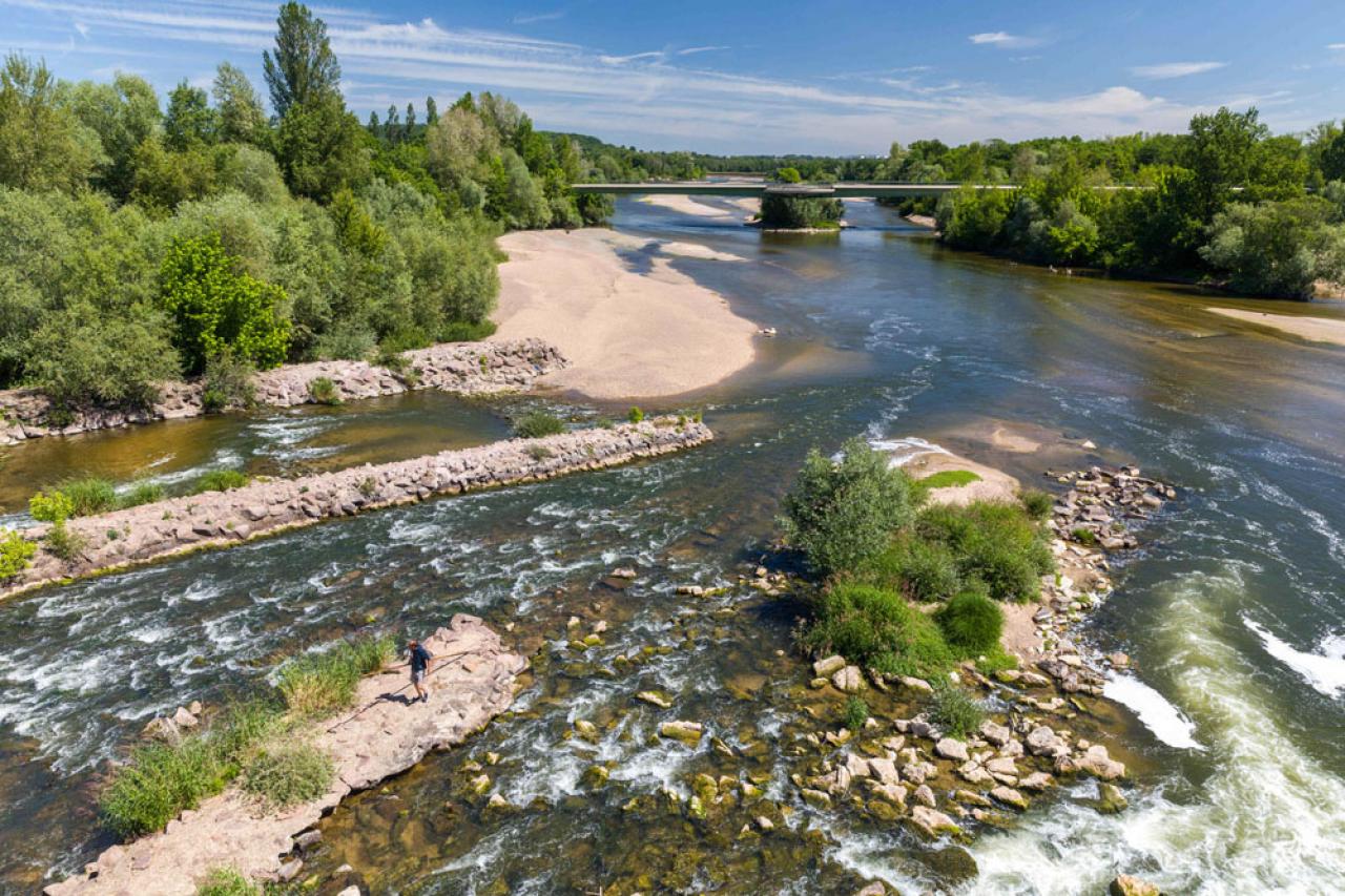 A view of the Allier river seen from the Guetin canal bridge in Cuffy, France on August 9, 2022. With an early heatwave in June and an unusually hot and dry month of May, the bed of the Loire has reached a lower level than usual, so much so that the river can be crossed on foot in certain places. Two-thirds of the country are at crisis level for drought. Four recent heatwaves have triggered weeks of wildfires and reduced the mighty Loire to a stream in some stretches. Last week, the government said 100 places were without safe tap water. Photo by Pascal Avenet/ABACAPRESS.COM