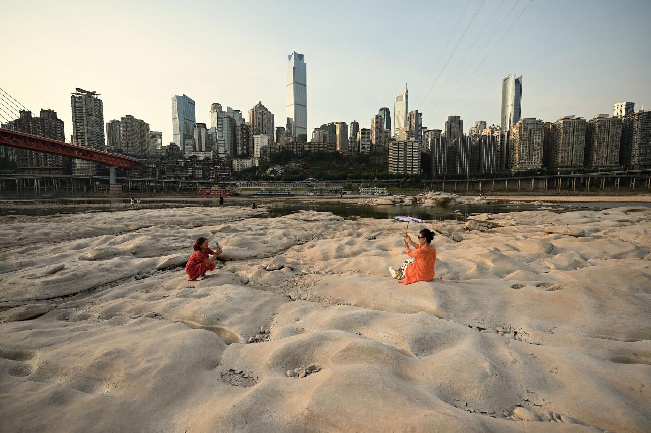 TOPSHOT - People are seen at the dried-up riverbed of the Jialing river, a tributary of the Yangtze River in China's southwestern city of Chongqing on August 25, 2022. (Photo by Noel Celis / AFP) (Photo by NOEL CELIS/AFP via Getty Images)
