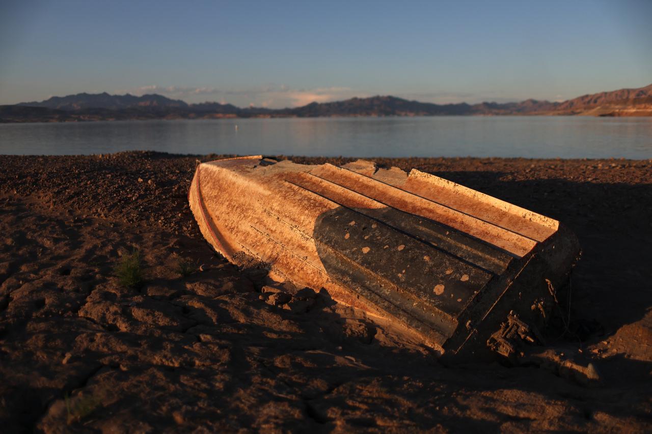 LAKE MEAD NATIONAL RECREATION AREA, NEVADA - AUGUST 19: A previously sunken boat sits on the banks of Lake Mead on August 19, 2022 in Lake Mead National Recreation Area, Nevada. The federal government announced plans to cut water allocations from the Colorado River Basin to Arizona and Nevada for the second year in a row and is asking residents to cut water consumption as the drought worsens. Water levels at Lake Mead stand at 27 percent of capacity, its lowest level since being filled in the 1930s following the construction of the Hoover Dam. The lake's water levels have fallen an estimated 175 feet since 2000.   Justin Sullivan/Getty Images/AFP (Photo by JUSTIN SULLIVAN / GETTY IMAGES NORTH AMERICA / Getty Images via AFP)