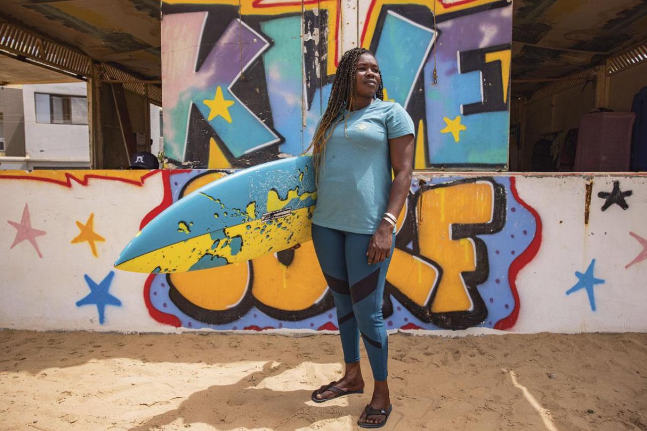 Khadjou Sambe, 27 ans, est la première surfeuse professionnelle du Sénégal. En 2018, grâce aux réseaux sociaux, Rhonda Harper repère son talent et l’invite à surfer en Californie, où elle habite. Aujourd’hui, l’Américaine et la Sénégalaise forment un binôme engagé pour que les Noires soient mieux représentées dans la compétition.