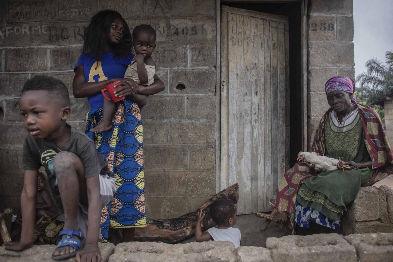 Gabali Lingimbe (R), wife of a National Institute for Agronomic Study and Research (INERA) civil servant who died a few years ago, sitts in front of his house in Yangambi, 100 km from the city of Kisangani, in the province of Tshopo, in the northeast of the Democratic Republic of Congo on September 2, 2022. - After the death of her husband, Gabali dedicated herself to survive with her family. Despite her husband being a public servant, the DRC government does not provide for the family after his death. (Photo by Guerchom Ndebo / AFP)