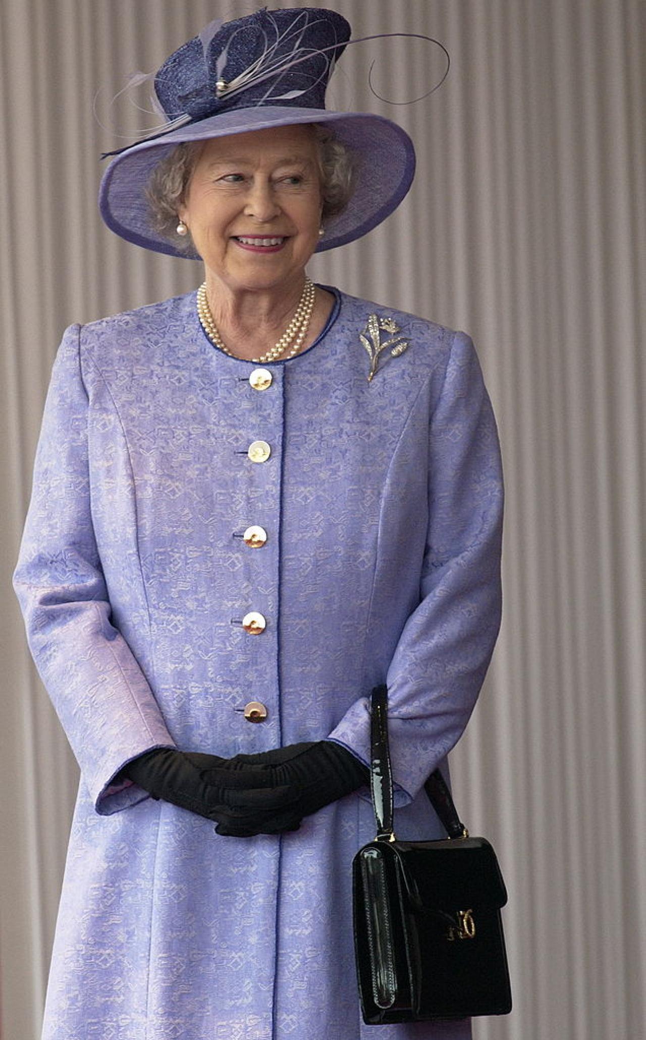 LONDON, UNITED KINGDOM - NOVEMBER 19:  Queen Elizabeth Ll Smiling During The State Visit Of The American President At Buckingham Palace.  The Queen Is Wearing A Mauve Coat With Matching Hat Which She Has Accessorized With Black Gloves And A Black Launer Handbag.  (Photo by Tim Graham Photo Library via Getty Images)