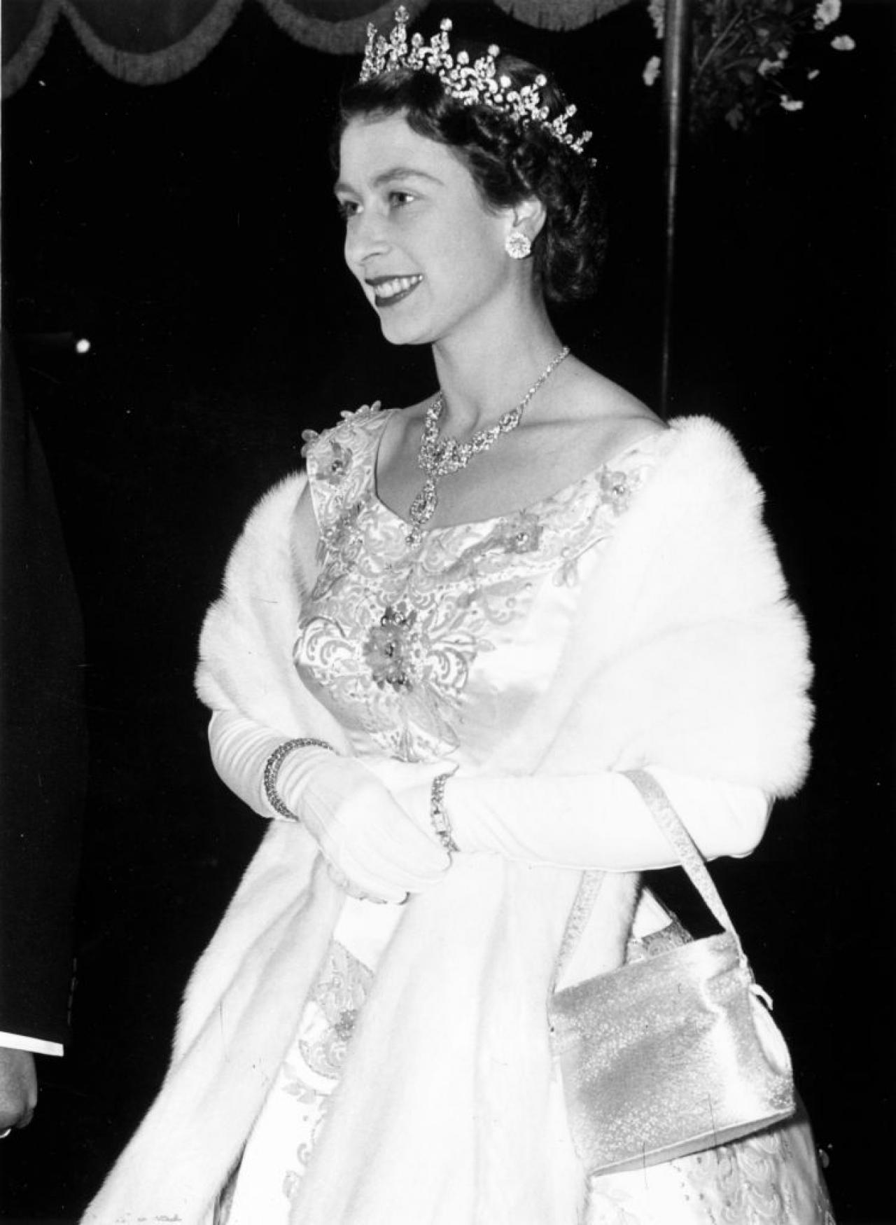 31st October 1955:  A regally adorned Queen Elizabeth II arriving at the Royal Performance of the film 'To Catch A Thief' at the Odeon Cinema, Leicester Square.  (Photo by Monty Fresco/Topical Press Agency/Getty Images)