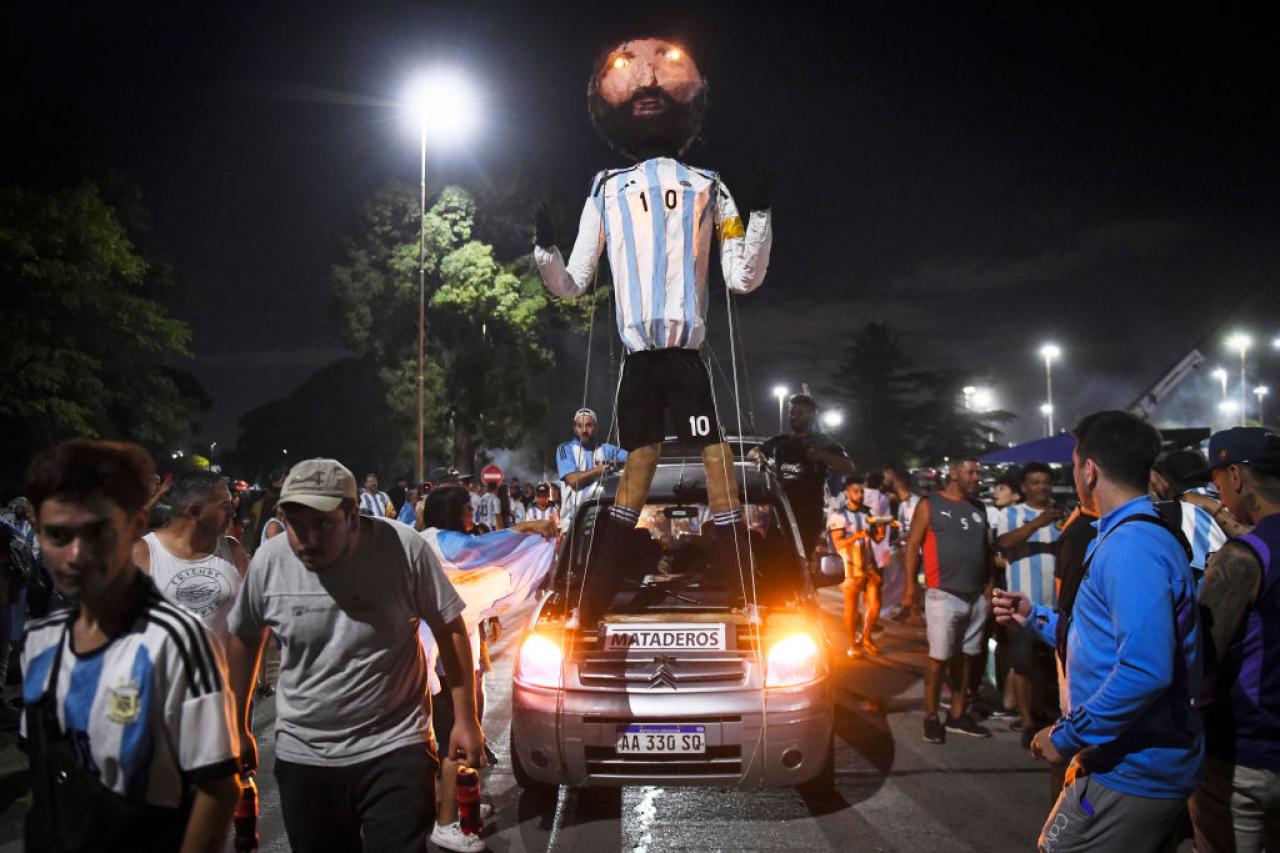 BUENOS AIRES, ARGENTINA - DECEMBER 19: Fans of Argentina display a Lionel Messi figure outside Argentina's training ground before the arrival of the Argentina men's national football team after winning the FIFA World Cup Qatar 2022 on December 20, 2022 in Buenos Aires, Argentina. (Photo by Rodrigo Valle/Getty Images)