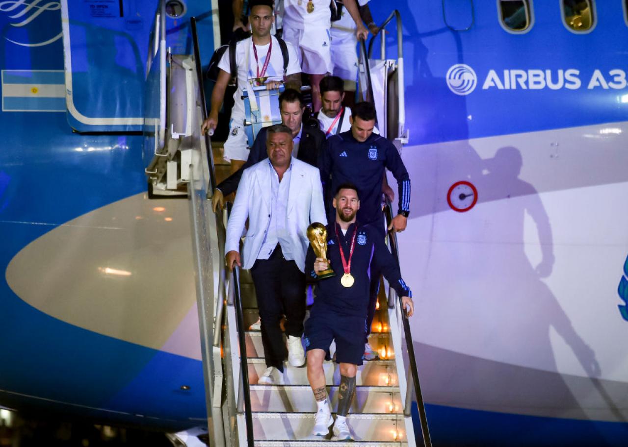 BUENOS AIRES, ARGENTINA - DECEMBER 20: Lionel Messi, Claudio Tapia, Lionel Scaloni get off the plane with the FIFA World Cup during the arrival of the Argentina men's national football team after winning the FIFA World Cup Qatar 2022 on December 20, 2022 in Buenos Aires, Argentina. (Photo by Marcelo Endelli/Getty Images)