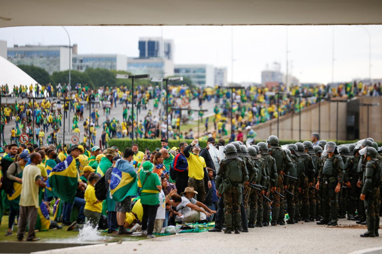 Veiligheidstroepen treden op als aanhangers van de Braziliaanse ex-president Jair Bolsonaro  buiten het Nationaal Congres van Brazilië betogen tegen president Luiz Inacio Lula da Silva in Brasilia, Brazilië, 8 januari 2023.