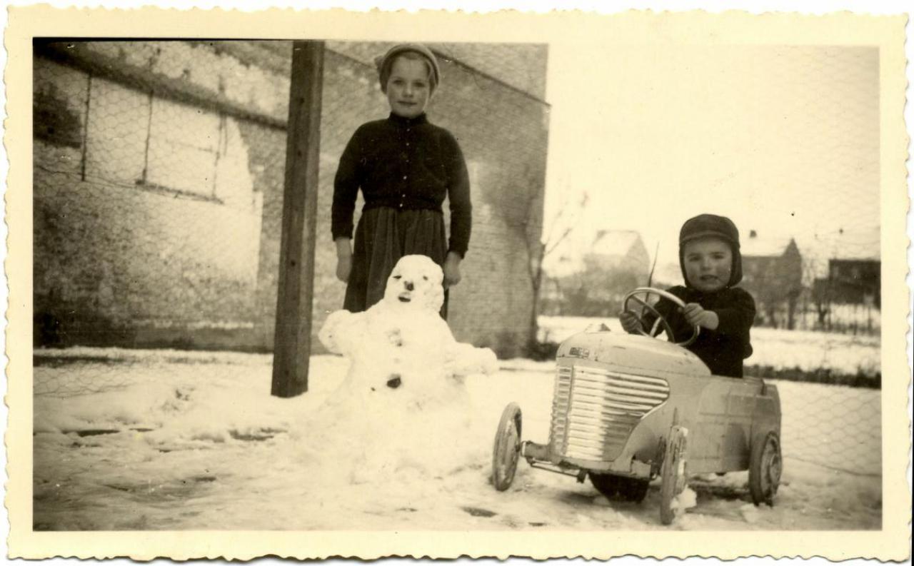 Monique en Jacques Devos, kinderen van Roger en Maria Delbeke, spelen in de sneeuw. Beiden poseren ze fier en warm ingeduffeld bij de sneeuwman die ze bouwden, Jacques in zijn Torck trapauto.