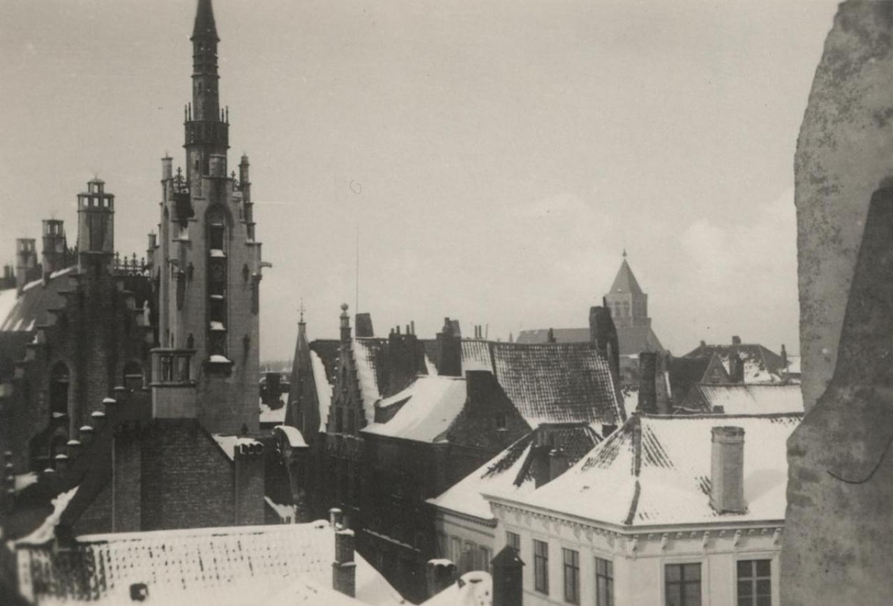 Brugse daken in de sneeuw in 1937 met links de Poortersloge en rechts op de achtergrond de Sint-Jakobskerk.