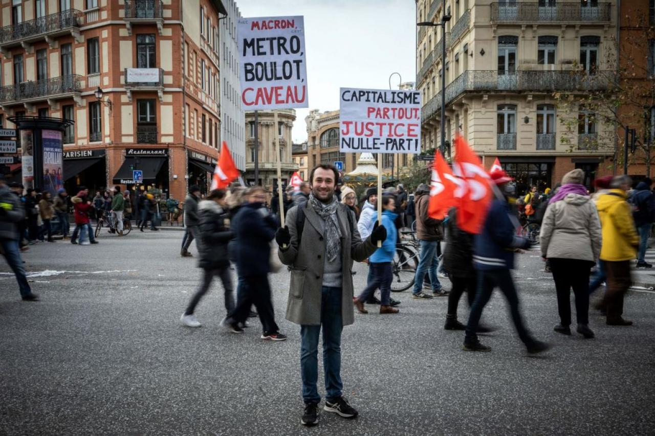 Clement, a 28-year-old teacher, poses with a placard during a rally called by French trade unions in Toulouse, southwestern France, on January 19, 2023. - A day of strikes and protests kicked off in France on January 19, 2023 set to disrupt transport and schooling across the country in a trial for the government as workers oppose a deeply unpopular pensions overhaul. (Photo by Lionel BONAVENTURE / AFP) (Photo by LIONEL BONAVENTURE/AFP via Getty Images)