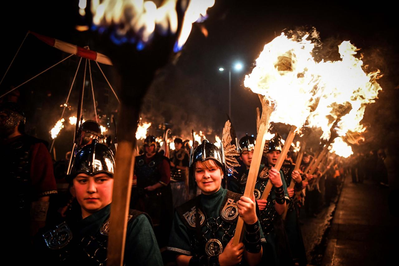 Young participants parade through the streets in Lerwick, Shetland Islands on January 31, 2023 as they take part in the Junior Up Helly Aa fire festival. - Up Helly Aa celebrates the influence of the Scandinavian Vikings in the Shetland Islands and culminates with up to 1,000 'guizers' (men in costume) throwing flaming torches into their Viking longboat and setting it alight later in the evening. (Photo by Andy Buchanan / AFP)