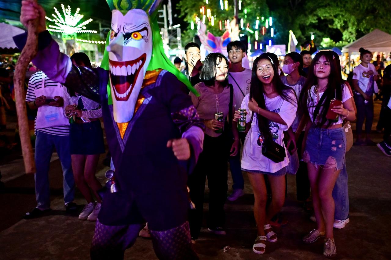 This photo taken on June 23, 2023 shows festival-goers attending the annual Phi Ta Khon carnival or ghost festival in Dan Sai district in northeastern Thailands Loei Province. (Photo by MANAN VATSYAYANA / AFP)