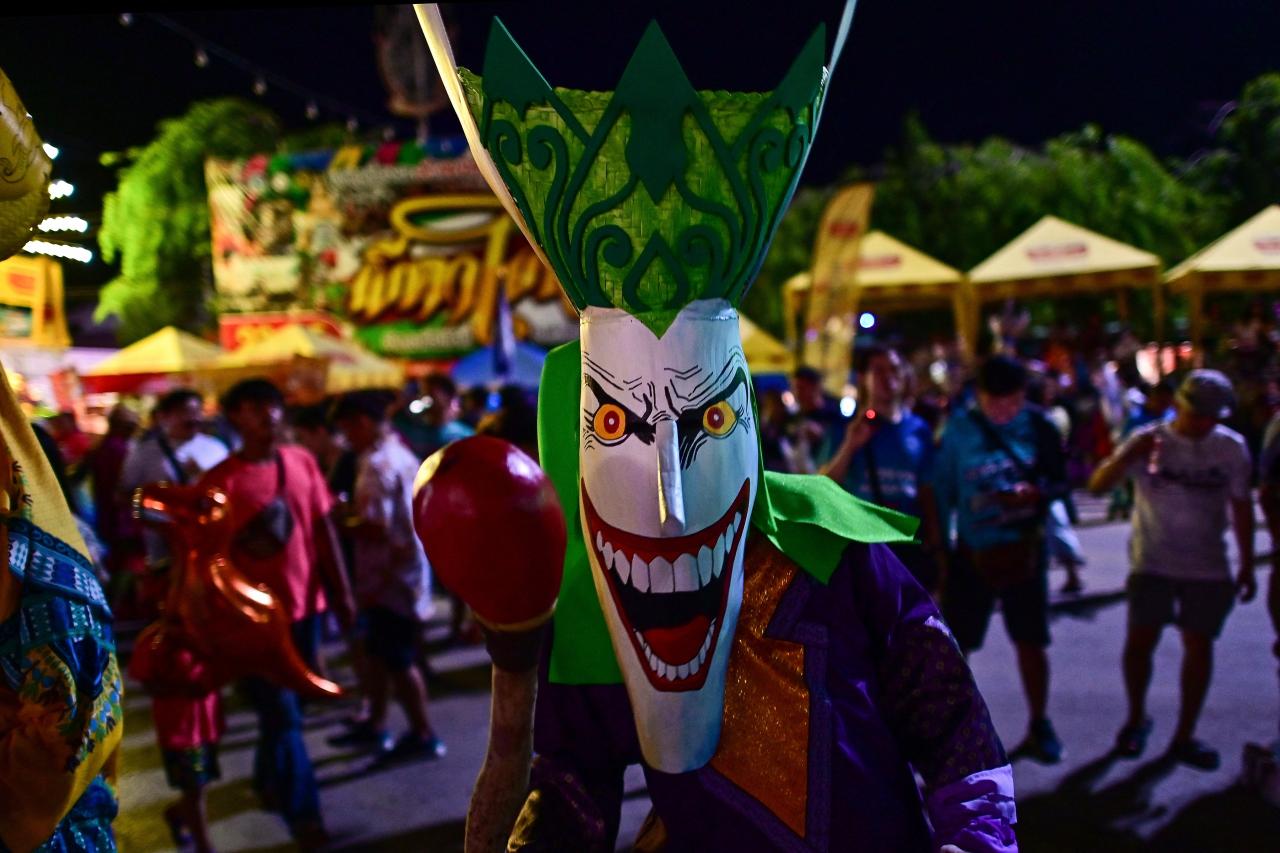 This photo taken on June 23, 2023 shows festival-goers wearing ghost masks and colorful costumes while dancing at night during the annual Phi Ta Khon carnival or ghost festival in Dan Sai district in northeastern Thailands Loei Province. (Photo by MANAN VATSYAYANA / AFP)