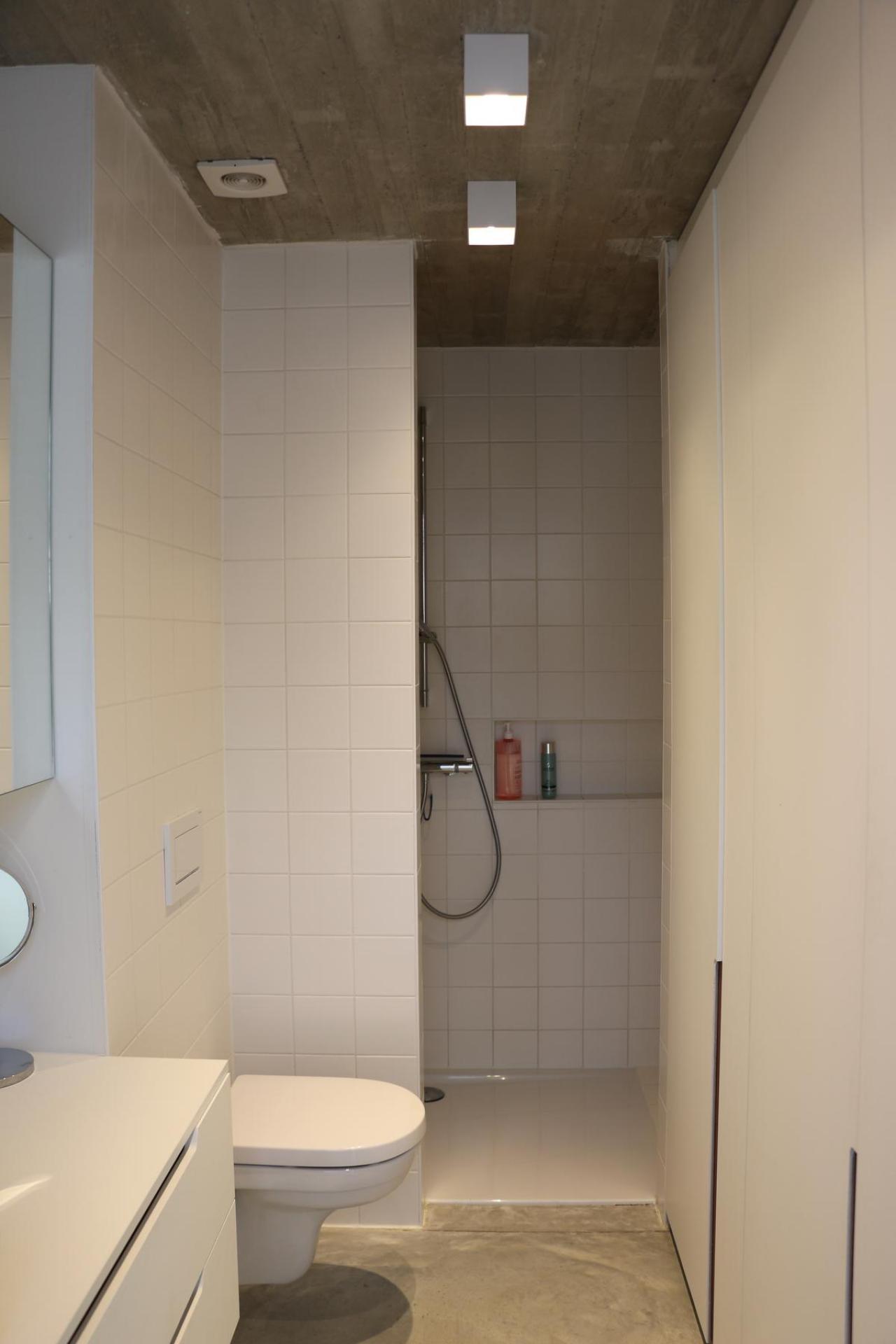 Het betonnen plafond is overal zichtbaar, ook in de doucheruimte.