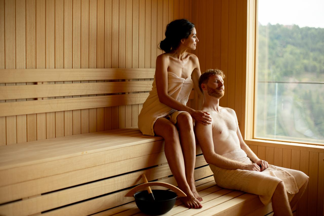 Handsome young couple relaxing in the sauna