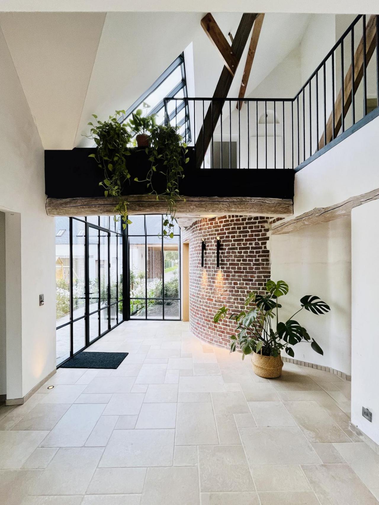 De stalen serre geeft een bijzonder accent aan de inkomhal.