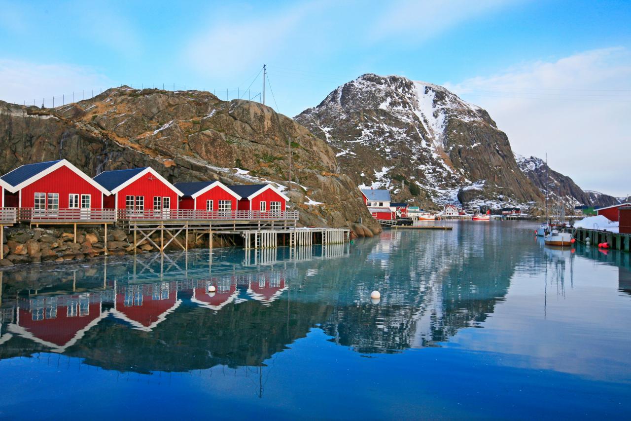 Des maisons typiques se reflètent dans les eaux d’un fjord.