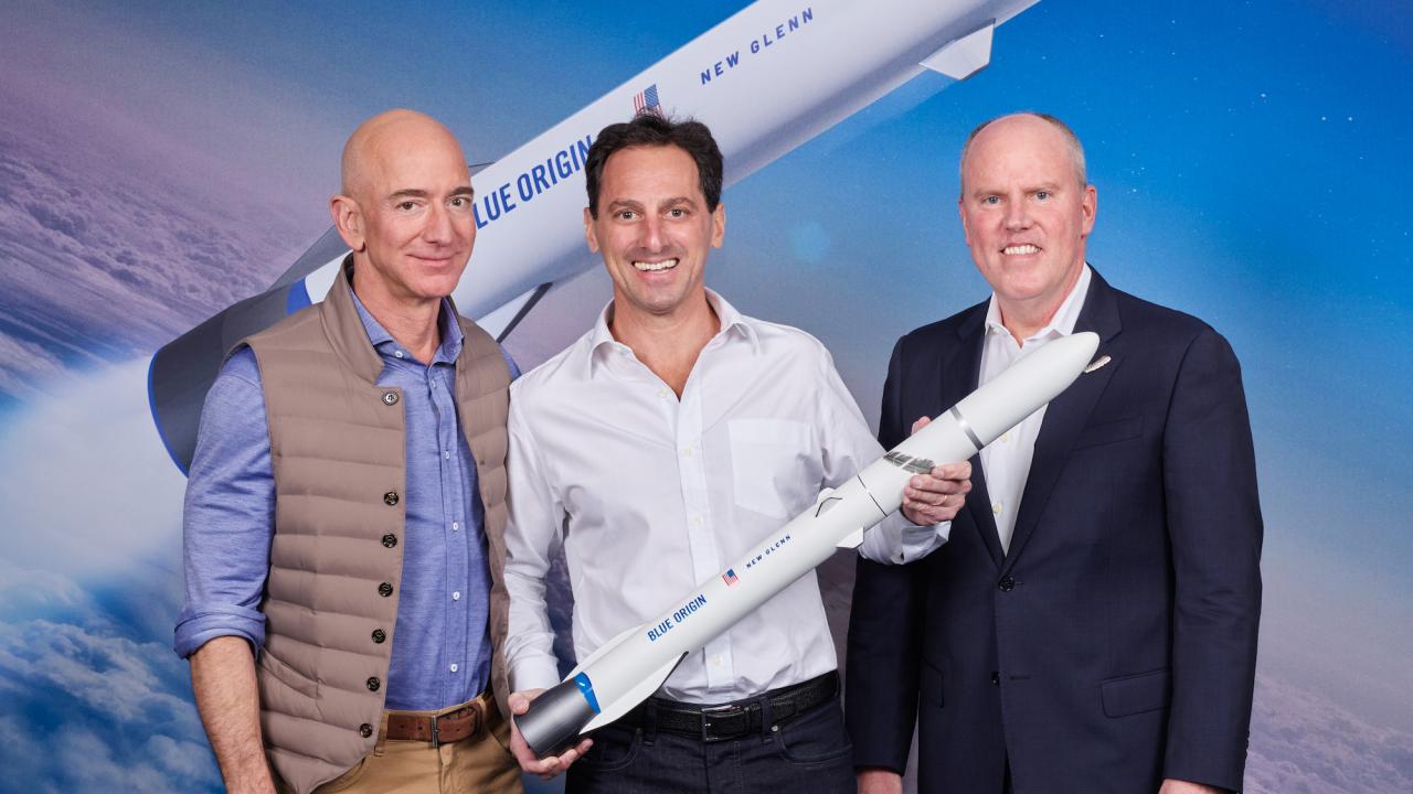 Een schaalmodel van de New Glenn, met links in beeld Blue Origin-baas Jeff Bezos.