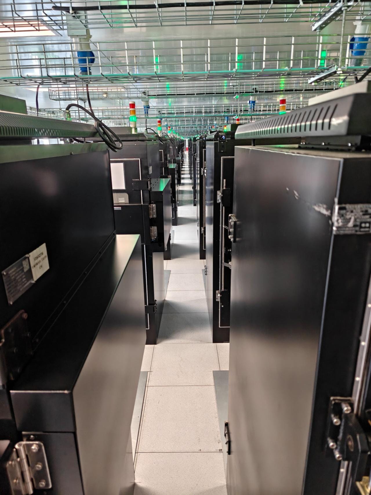 Verspreid over 200 cabinets worden hier om en nabij de 20.000 smartphones simultaan getest.