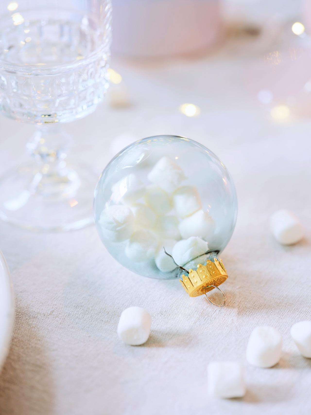 Een leuk alternatief voor nepsneeuw: vul glazen kerstballen met minimarshmallows en strooi de rest als sneeuwvlokjes over de tafel voor een sprookjesachtig effect.