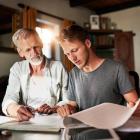 Vader en zoon bekijken documenten in de woonkamer