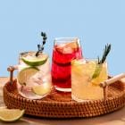 Drie mocktails op een dienbord met blauwe achtergrond.