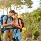 Koppen bekijkt smartphone tijdens wandeling.