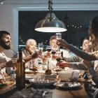 Familie heft het glas samen aan tafel met kerst.