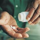 mannelijk hand met 2 medicijnen