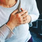 Vrouw drukt op borst ter hoogte van het hart