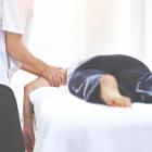 Patiënt wordt behandeld door zorgspecialist en wrijft over linkerarm van patiënt.