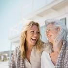 Twee vriendinnen van middelbare leeftijd lachen naar elkaar.