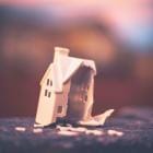 Illustratie van miniatuurwoning met een verwoeste gevel.