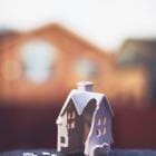 Illustratie van miniatuurwoning met een verwoeste gevel.