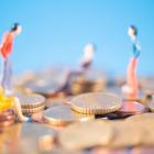 Kleine figuurtjes die op personen lijken staan op torens van eurocenten.