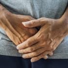 Man die beide handen voor zijn kruis houdt