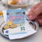 Biljet van 20 euro en enkele munten liggen op de rekening van een tafel.