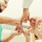 Arts, verpleegkundige en patiënt voegen handen samen.