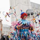 Man verkleed in kleurrijk carnavalskostuum danst.
