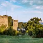 Zicht op de stadsmuur met de zee en cruiseschip op de achtergrond.