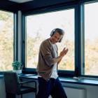 Man geniet thuis van muziek en danst met draadloze koptelefoon.